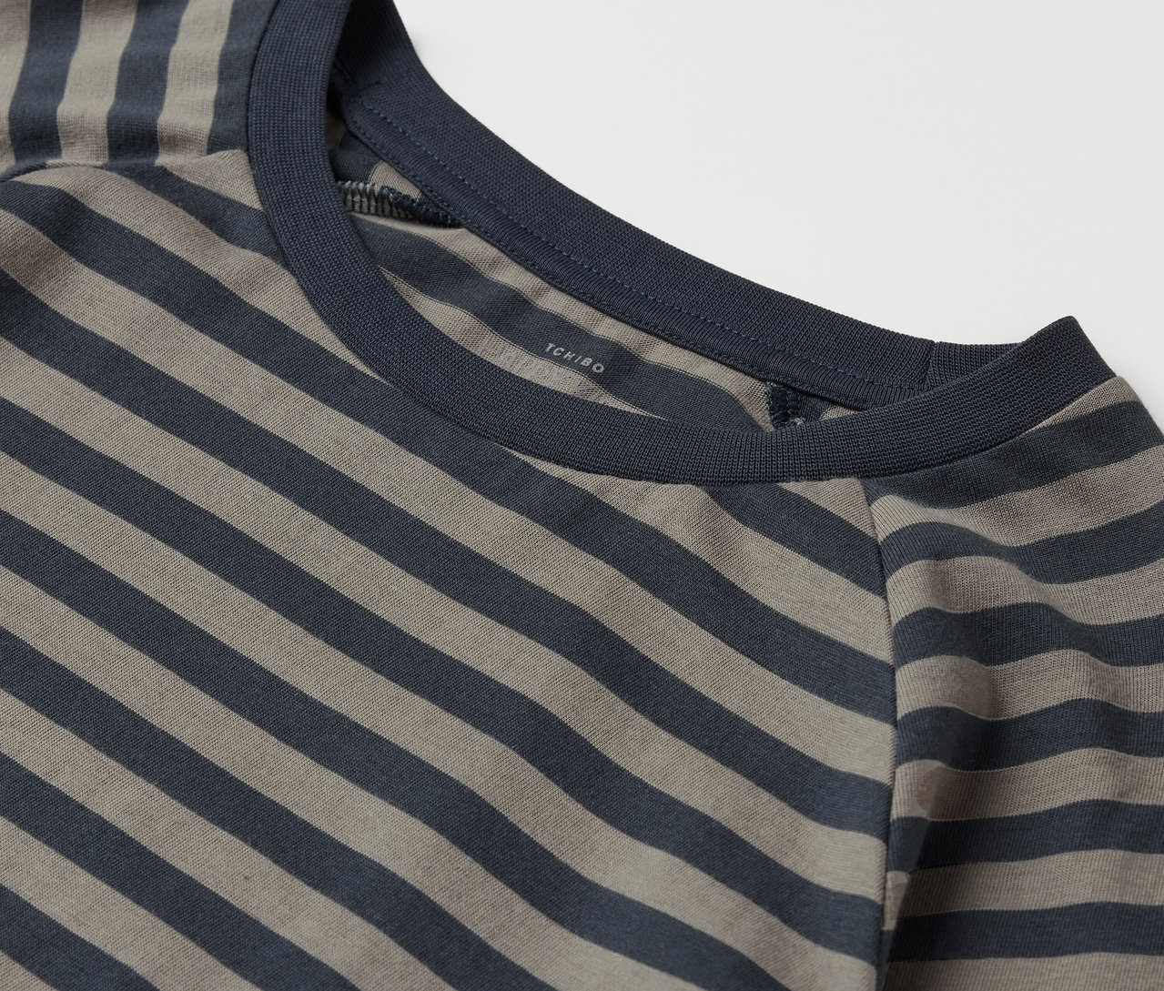Zbliżenie na khaki i granatowy T-shirt w paski z okrągłym dekoltem.