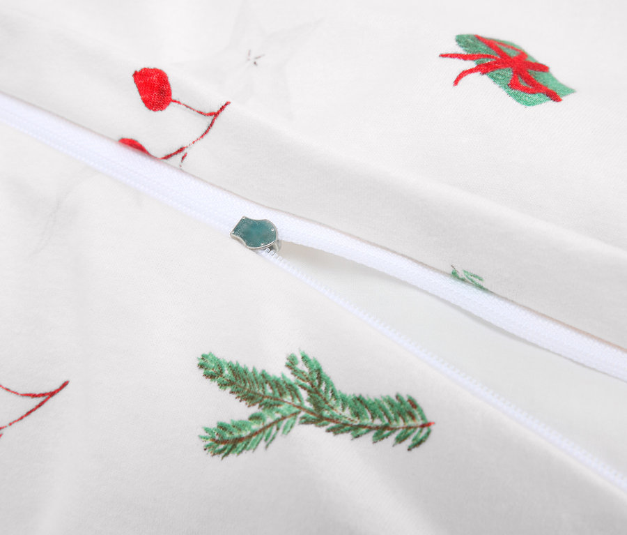 Detal białej pościeli z zamkiem błyskawicznym i motywami świątecznymi.