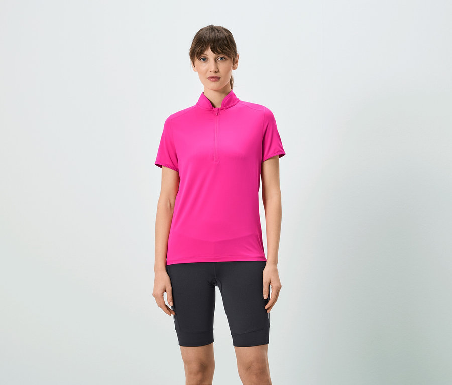 Kobieta ma na sobie różową koszulkę z krótkim zamkiem i czarne szorty.