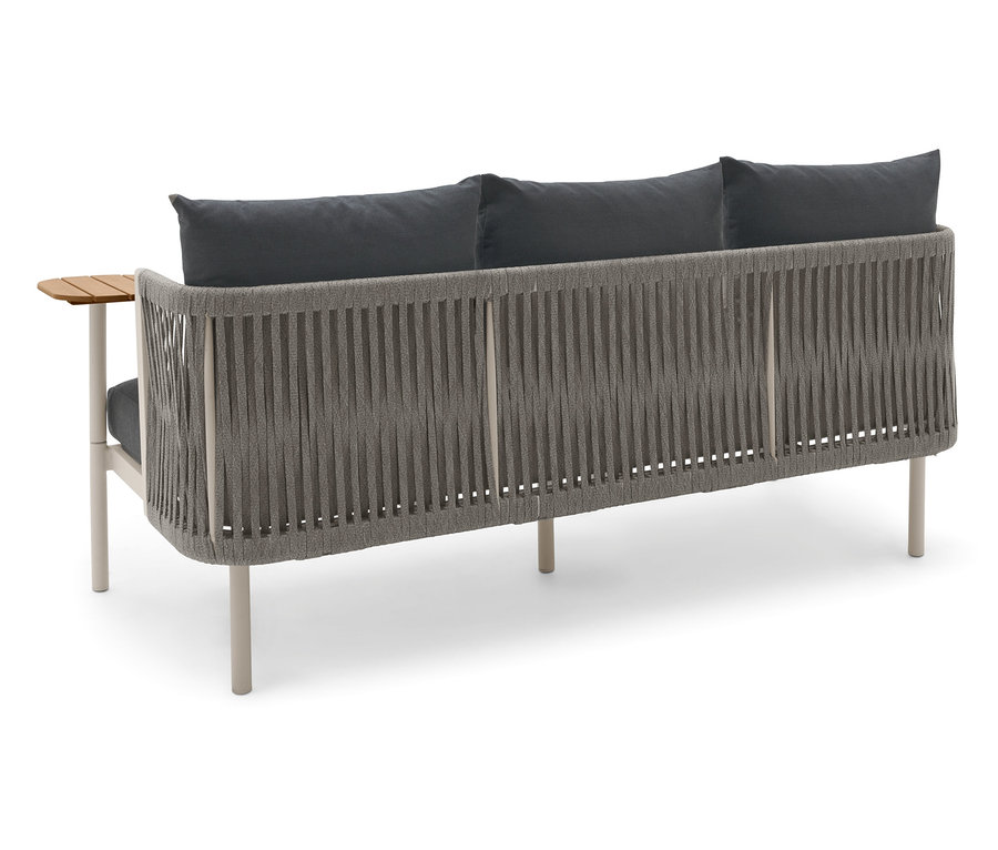 Widok z tyłu sofy ogrodowej z dwoma obrotowymi stolikami i szarymi poduszkami.