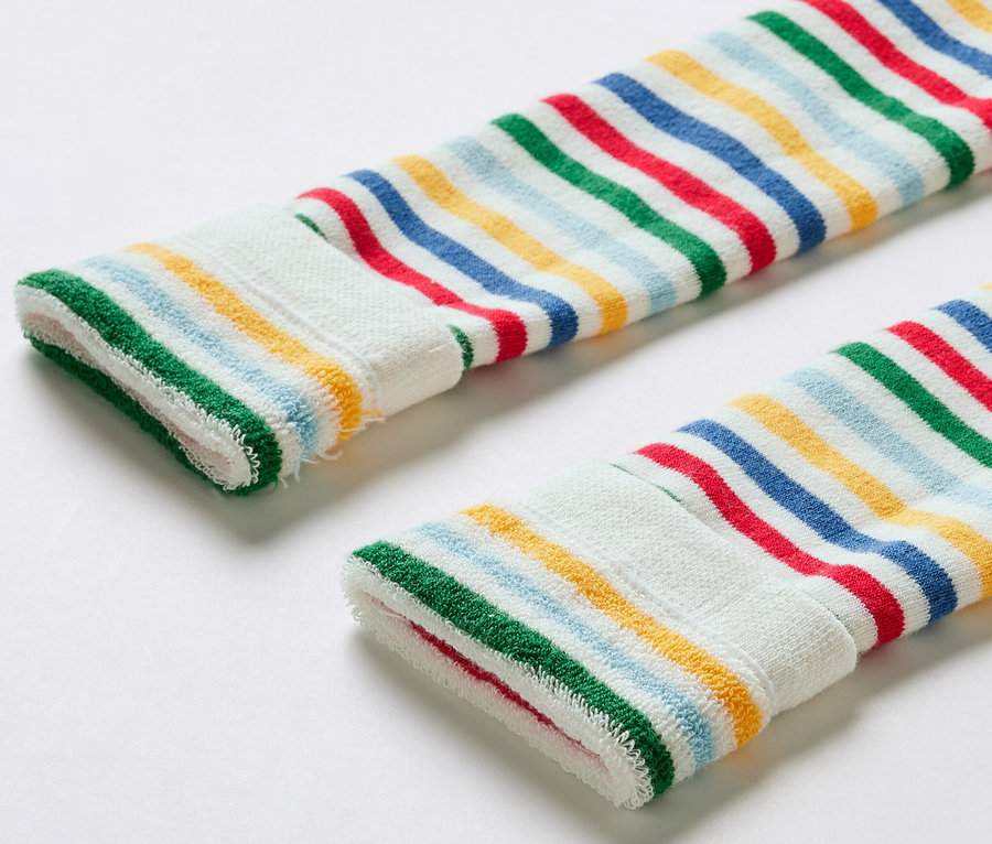 Zbliżenie na trzy pary legginsów termoaktywnych dla dzieci w kolorowe paski.