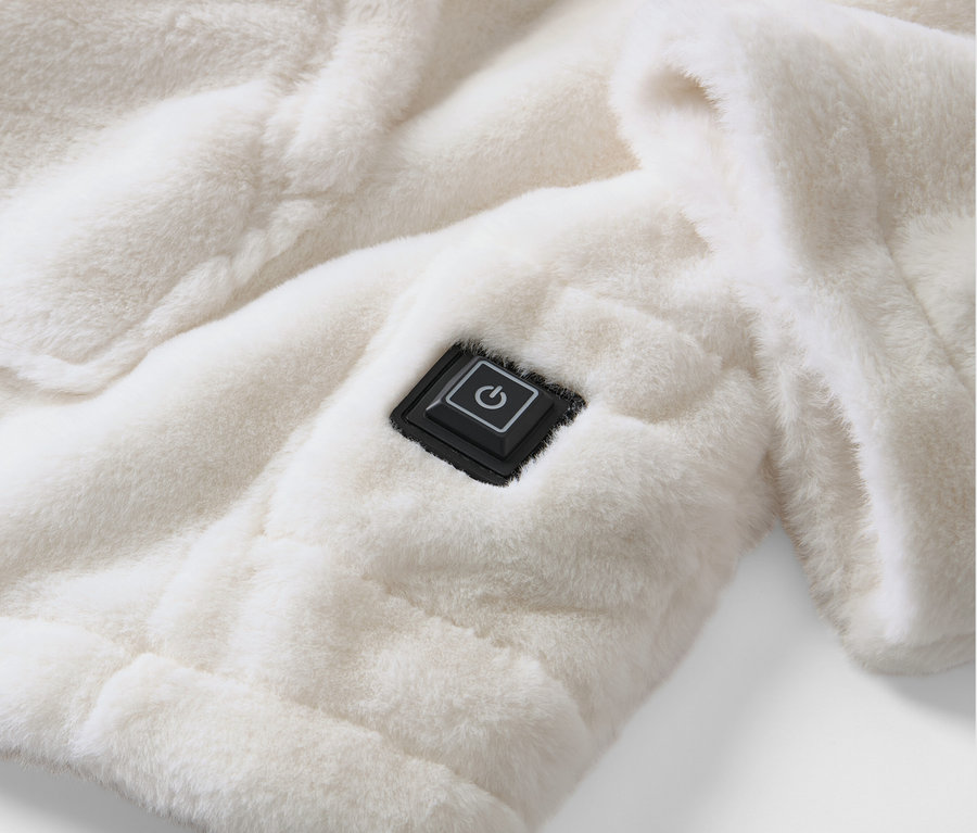 Szczegół białego, ogrzewanego swetra z akumulatorem z czarnym włącznikiem/wyłącznikiem.