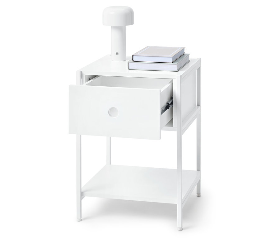 Biała szafka nocna z otwartą szufladą, lampą i książkami na górze.
