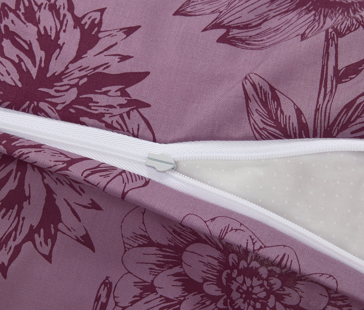 Zbliżenie fioletowej pościeli z bawełny renforcé w standardowym rozmiarze, z kwiatowym wzorem i zamkiem błyskawicznym.