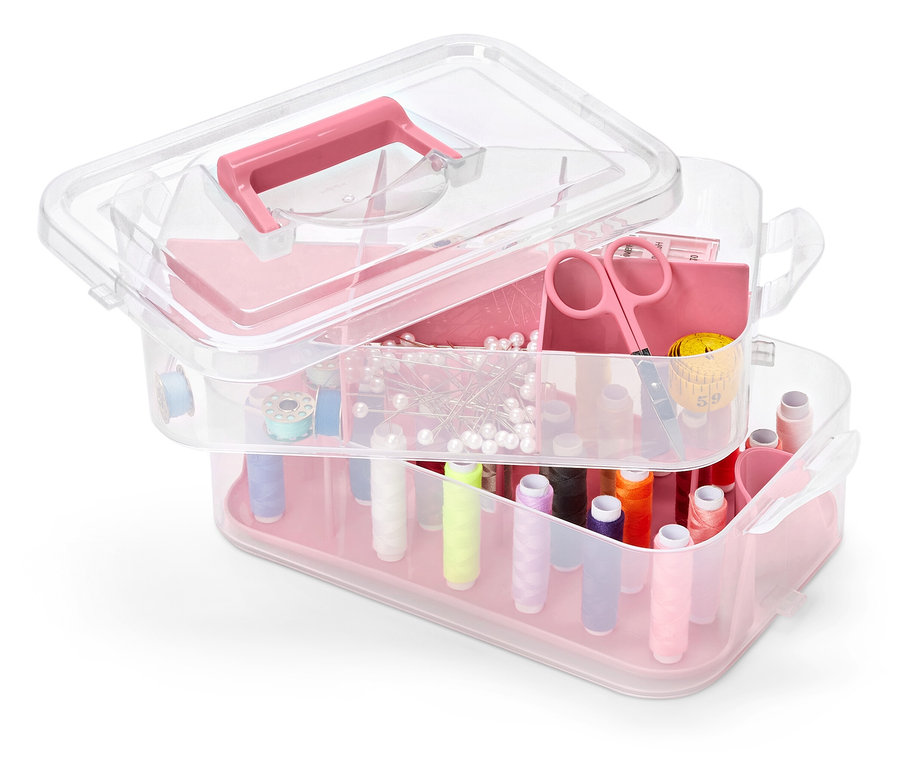 Wielopoziomowy, przezroczysty plastikowy organizer na narzędzia z różowymi akcentami, wypełniony akcesoriami do szycia.