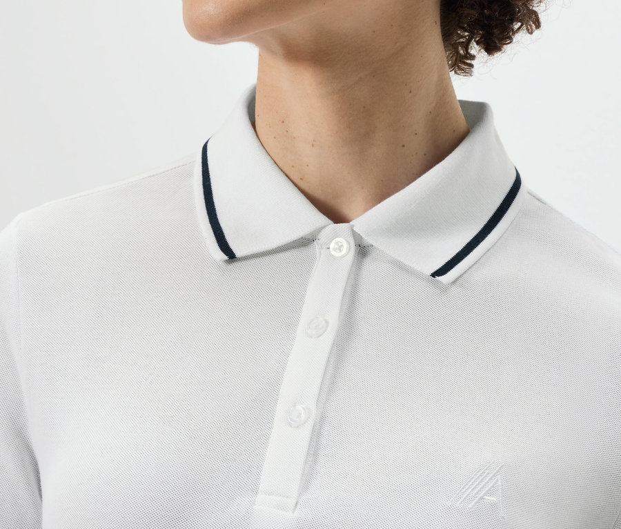 Górna część ciała osoby ubranej w białą funkcyjną koszulkę polo.