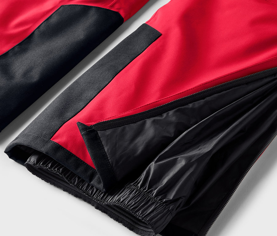 Szczegół czerwono-czarnych spodni z rozpiętym zamkiem na nogawce.