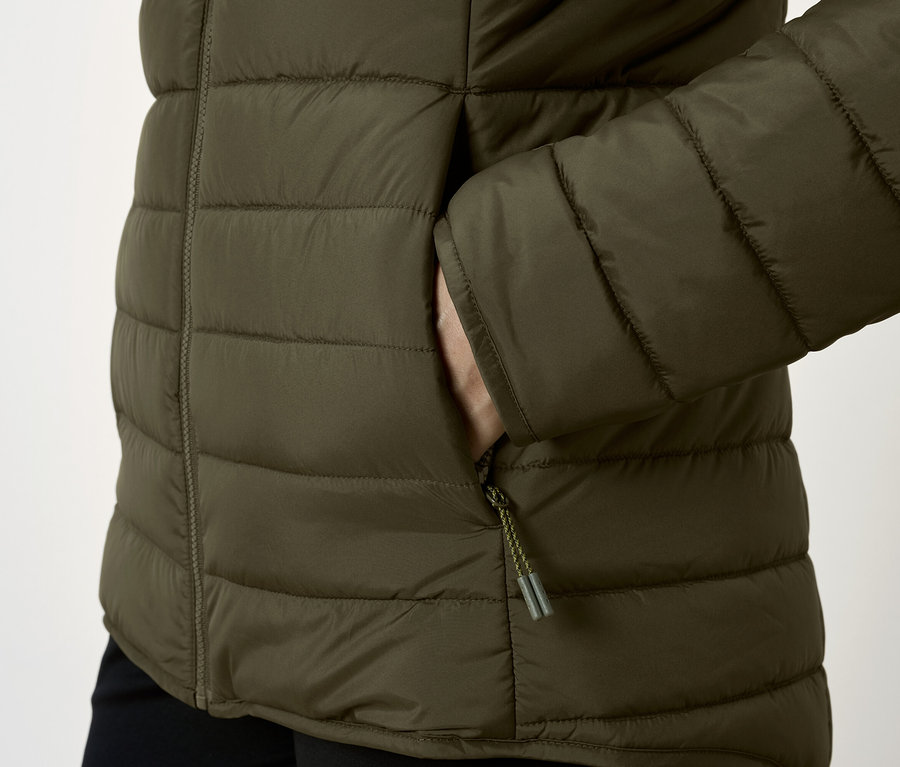 Zbliżenie na oliwkową kurtkę puchową z ręką w kieszeni.