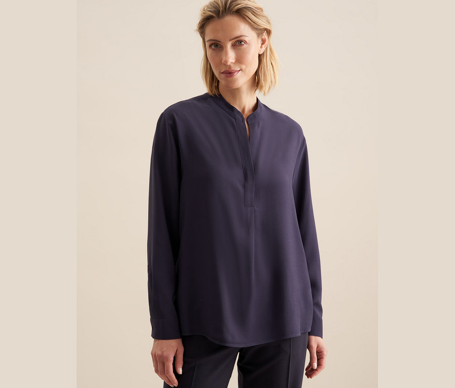 Kobieta ma na sobie tunikę z wiskozy Seidensticker.