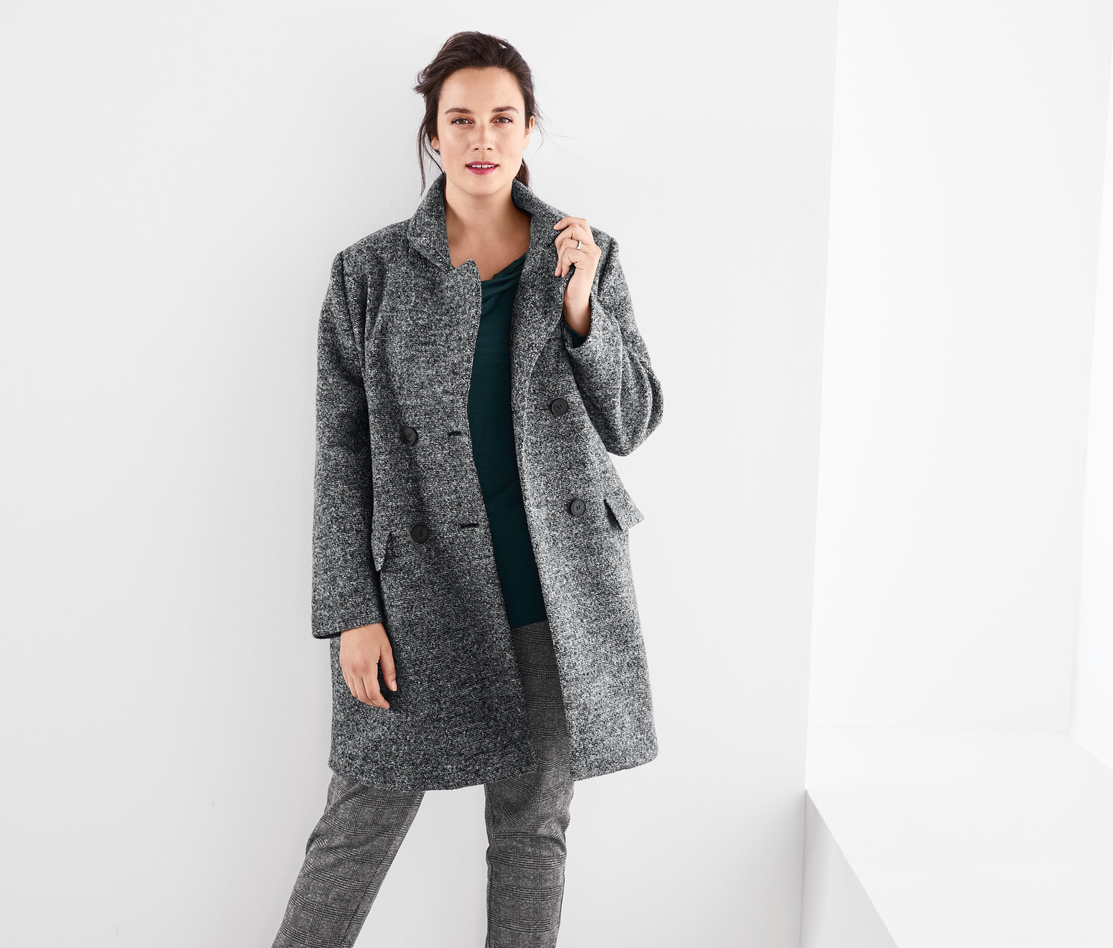 Kobieta ma na sobie płaszcz , bluzkę z dekoltem typu woda i spodnie dresowe .