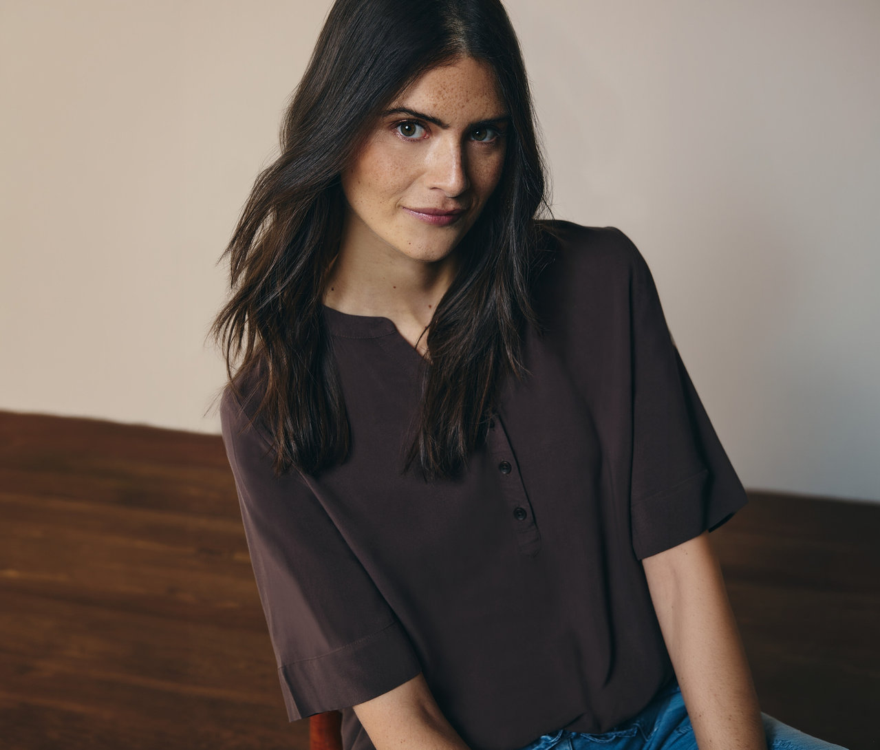 Kobieta ma na sobie brązową bluzkę tunikową CECIL i dżinsy.