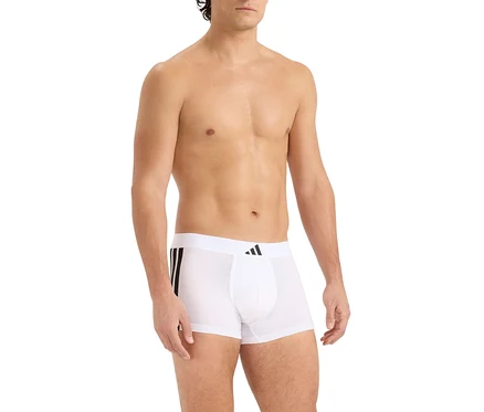 Mężczyzna bez koszulki, ubrany w białe bokserki z czarnymi paskami po boku i czarnym logo Adidas na pasie.
