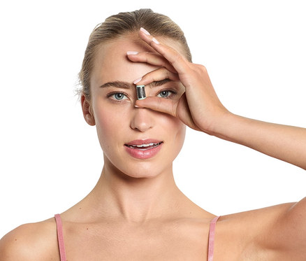 Kobieta trzyma mini depilator do twarzy przed okiem.