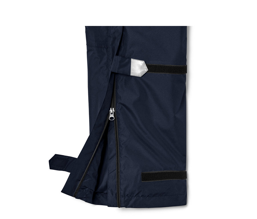 Zbliżenie na techniczne spodnie przeciwdeszczowe, uniseks, z rozpiętym zamkiem i elementem odblaskowym.