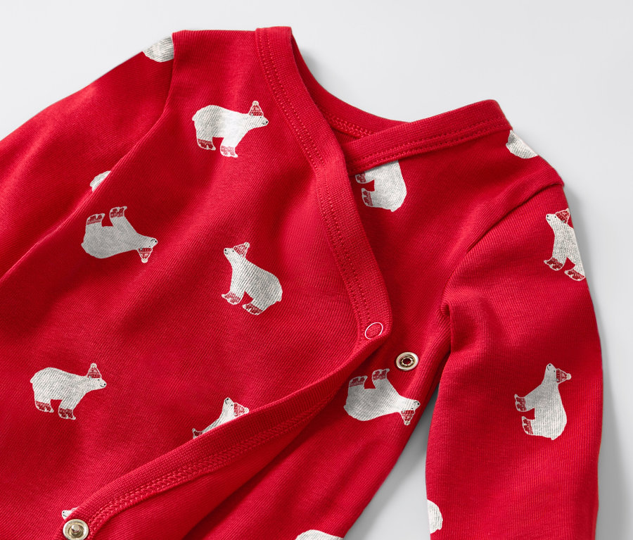 Szczegółowy widok czerwonego dziecięcego body z długim rękawem, w białe niedźwiedzie polarne.