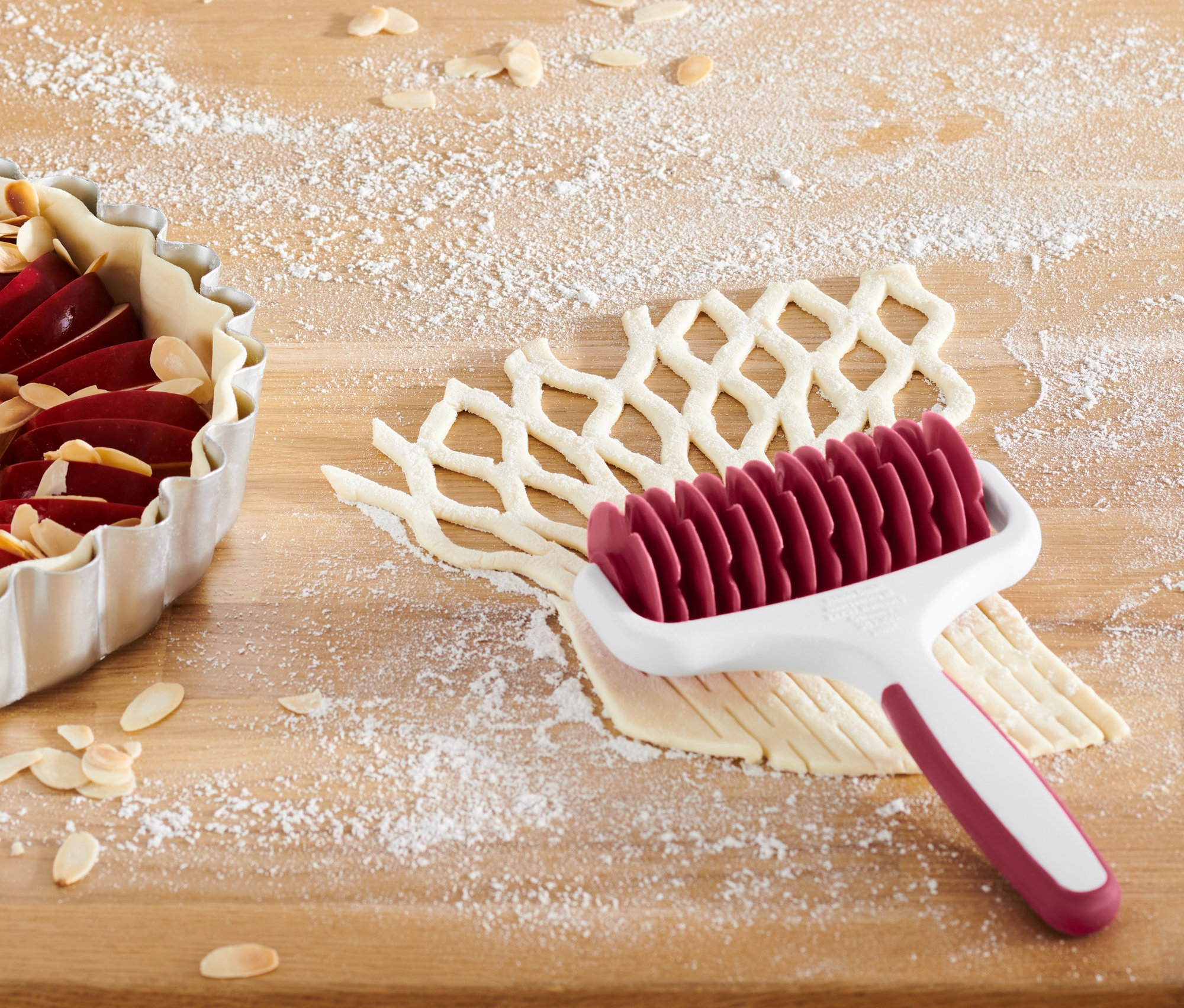 Wałek do kratkowania ciasta obok szarlotki.