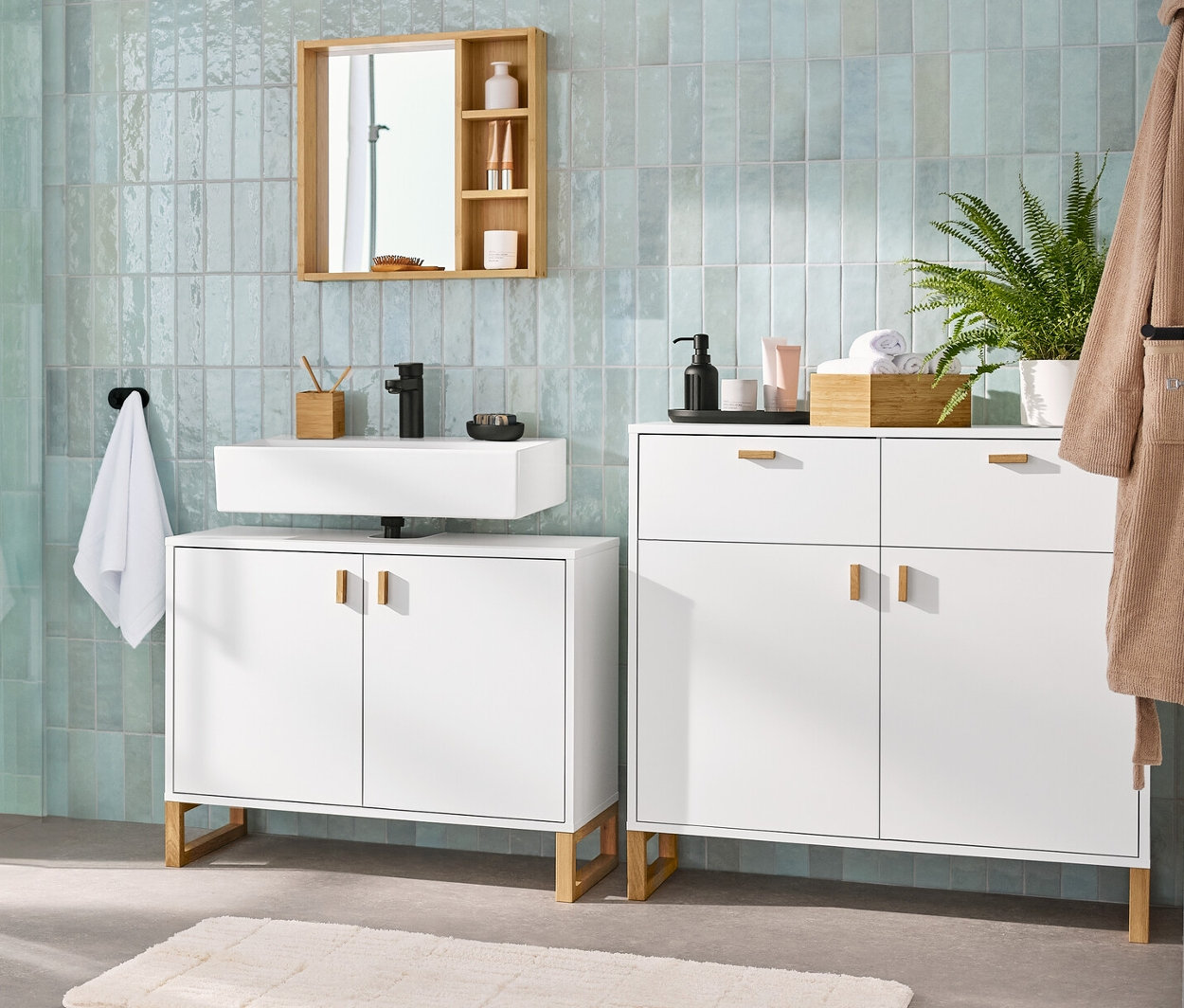 Wnętrze łazienki z szafką pod umywalkę, lustrem z półkami, szafką łazienkową i wysoką szafką łazienkową.