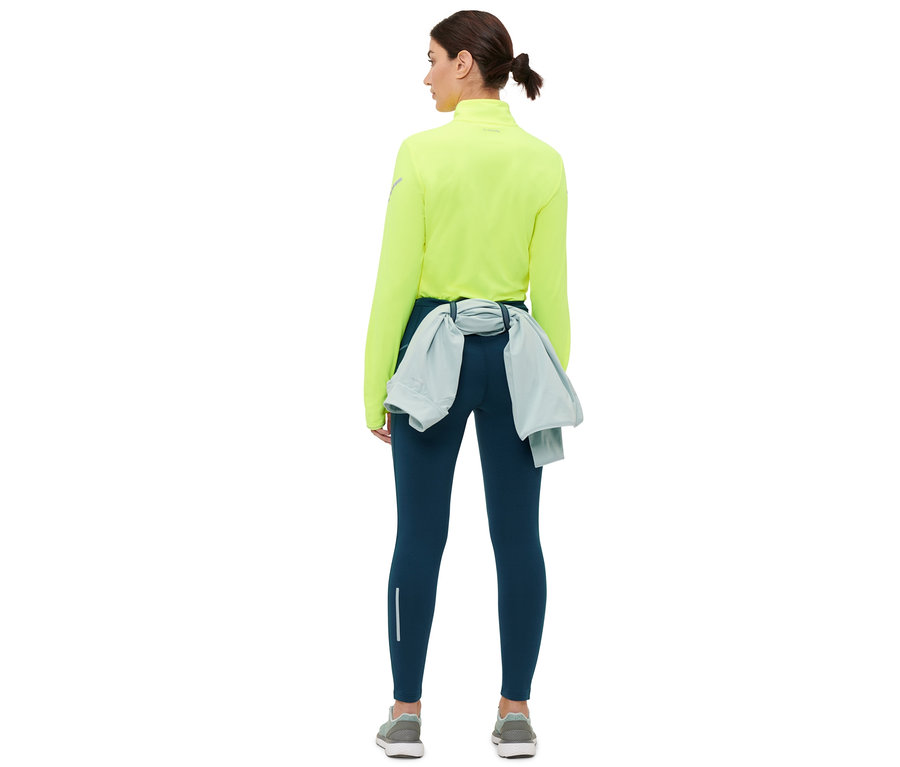 Kobieta od tyłu nosi granatowe ciepłochronne legginsy do biegania.