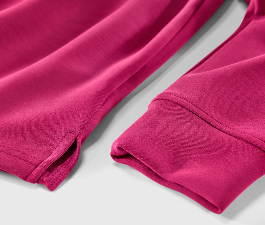 Zbliżenie różowej bluzy z kapturem z zawartością modalu, ukazujące brzeg rękawa i rozcięcie.