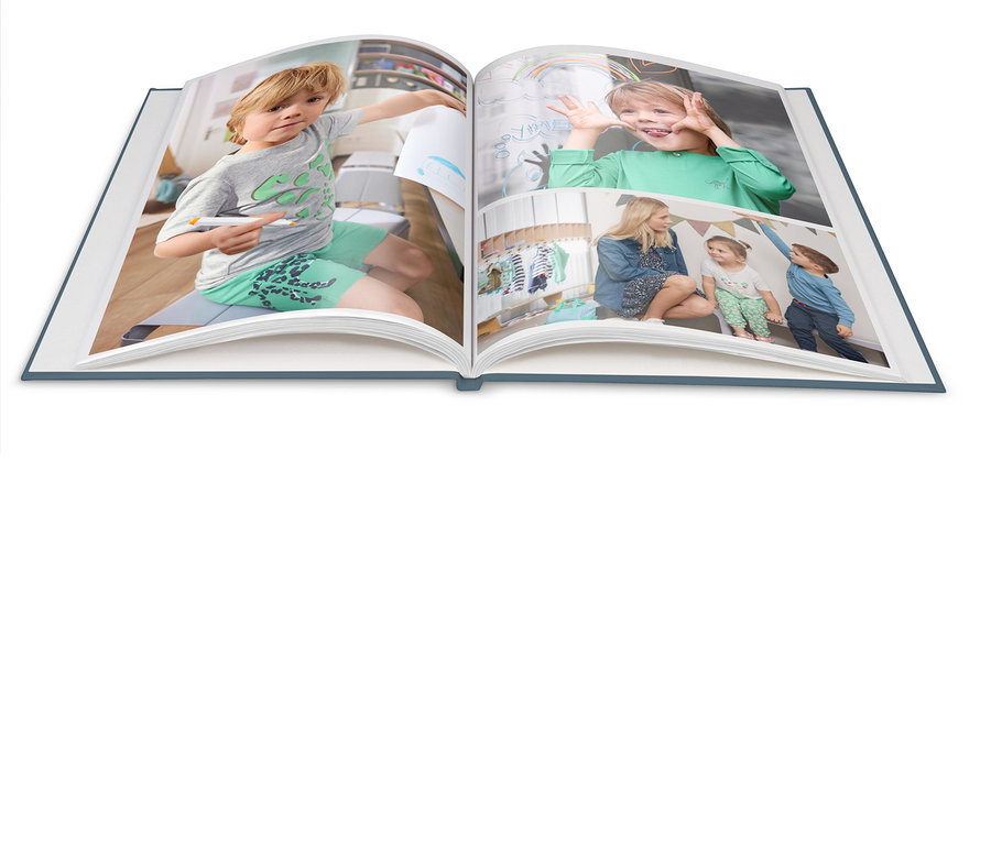 Otwarta fotoksiążka przedstawia chłopca rysującego markerem, chłopca robiącego miny i kobietę z dziećmi siedzącą pod namiotem.