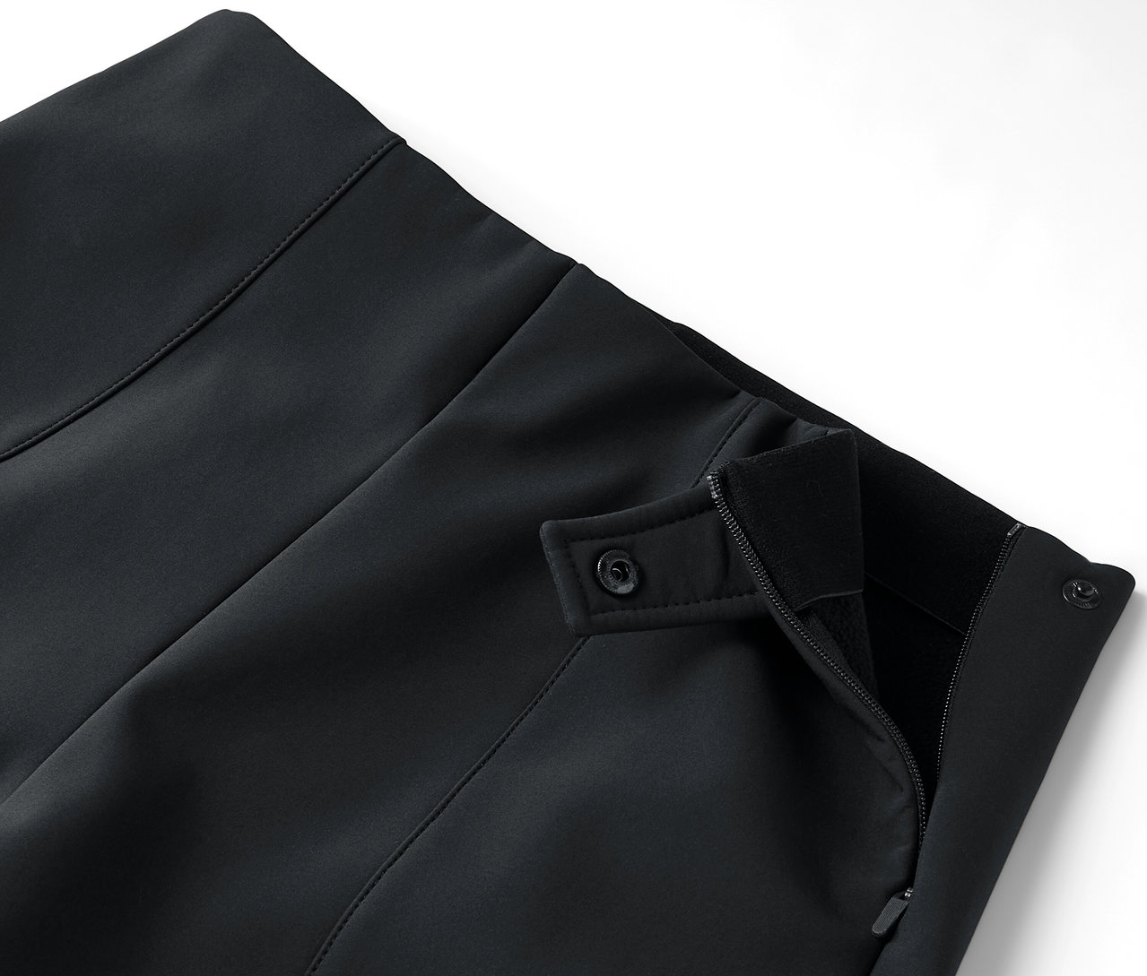 Szczegół czarnej spódnicy z zamkiem błyskawicznym i guzikami.