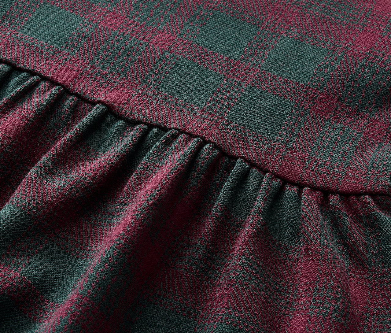 Zbliżenie na tkaninę w kratę czerwono-zieloną ze zmarszczeniami.