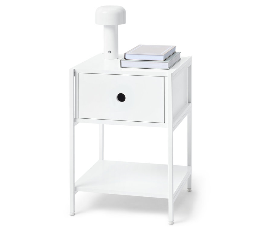 Biała szafka nocna z jedną szufladą, lampą i dwiema książkami na górze.