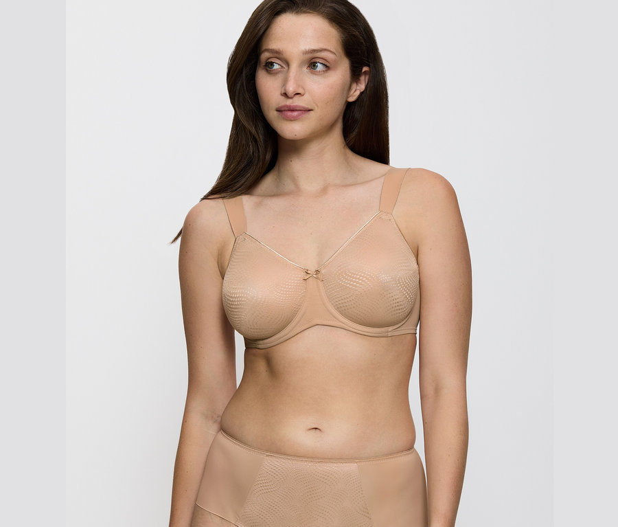 Kobieta ma na sobie biustonosz Triumph Essential „Minimizer W X” w kolorze skóry.