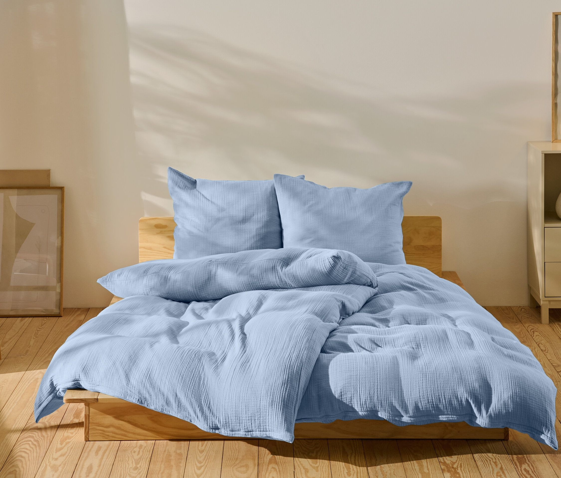 Jasnoniebieska pościel na łóżku w sypialni.