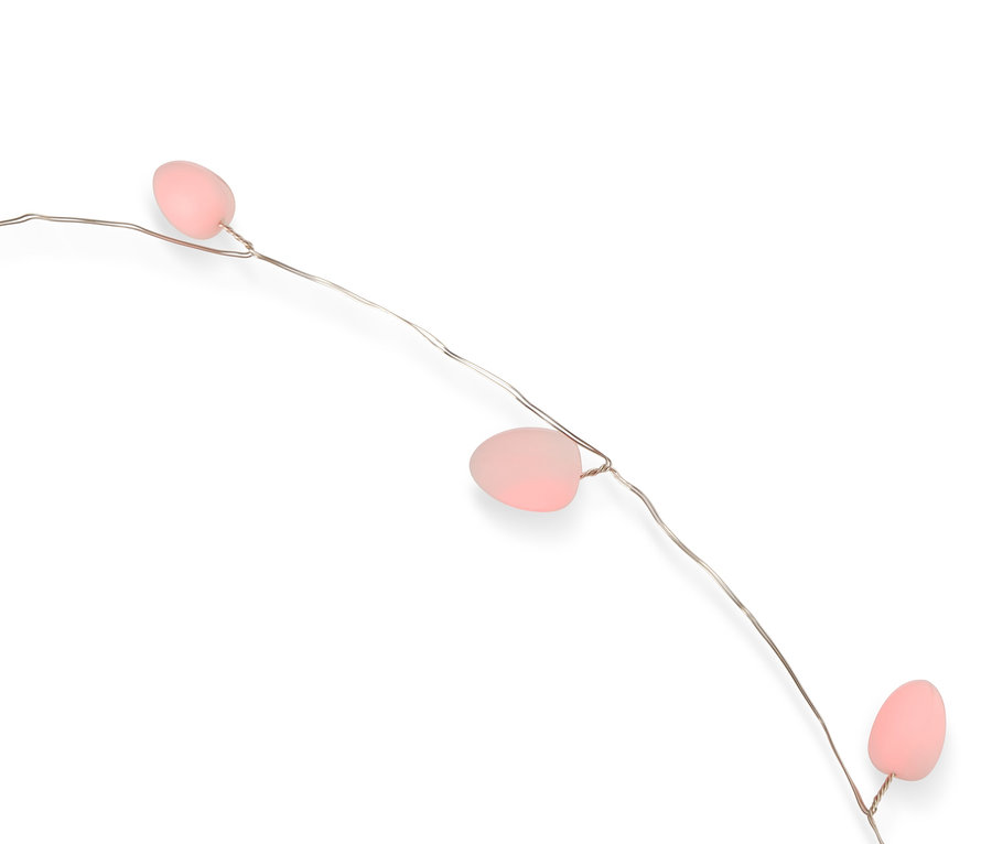 Zbliżenie sznura lampek z trzema różowymi jajkami na cienkim srebrnym drucie na białym tle.