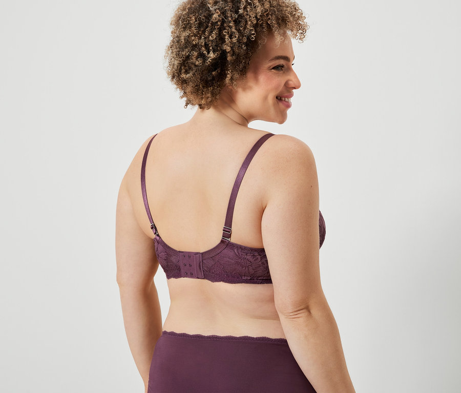 Kobieta w bordowym koronkowym biustonoszu i majtkach, widok z tyłu.