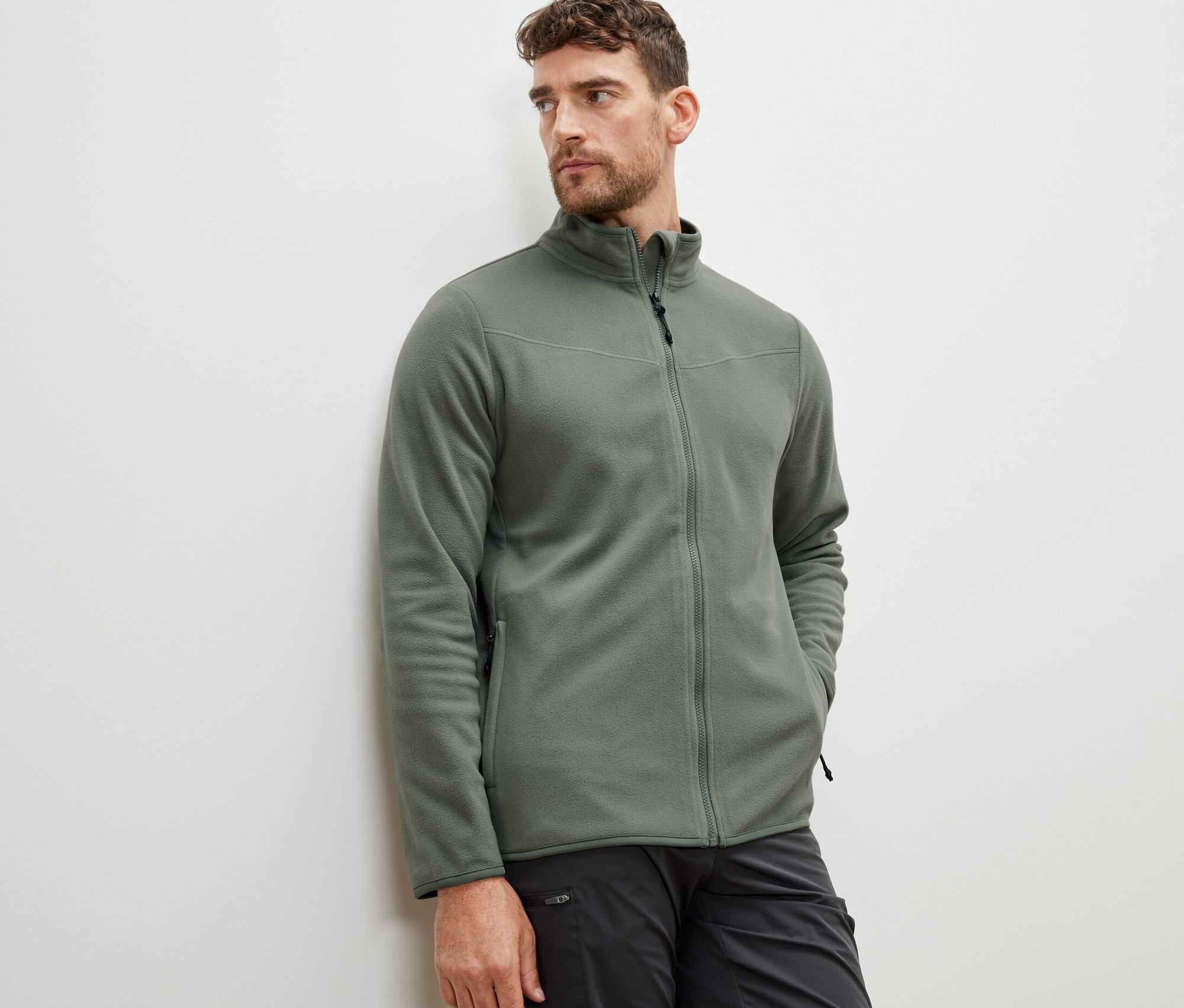 Mężczyzna ma na sobie bluzę z polaru khaki.