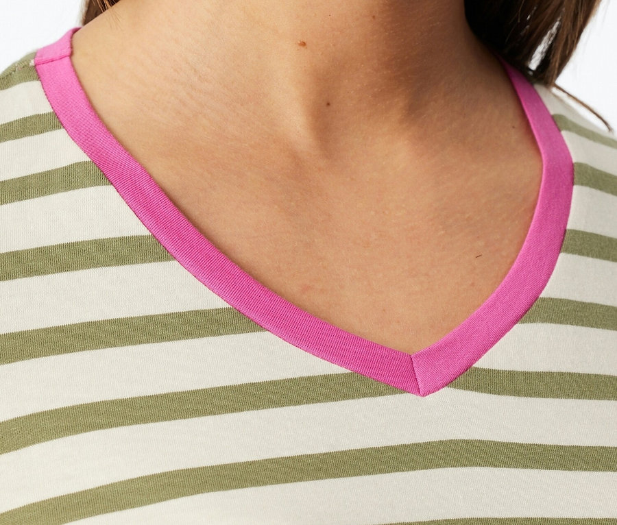 Zbliżenie kobiety w bluzce w paski z dekoltem w serek w kolorze różowym.