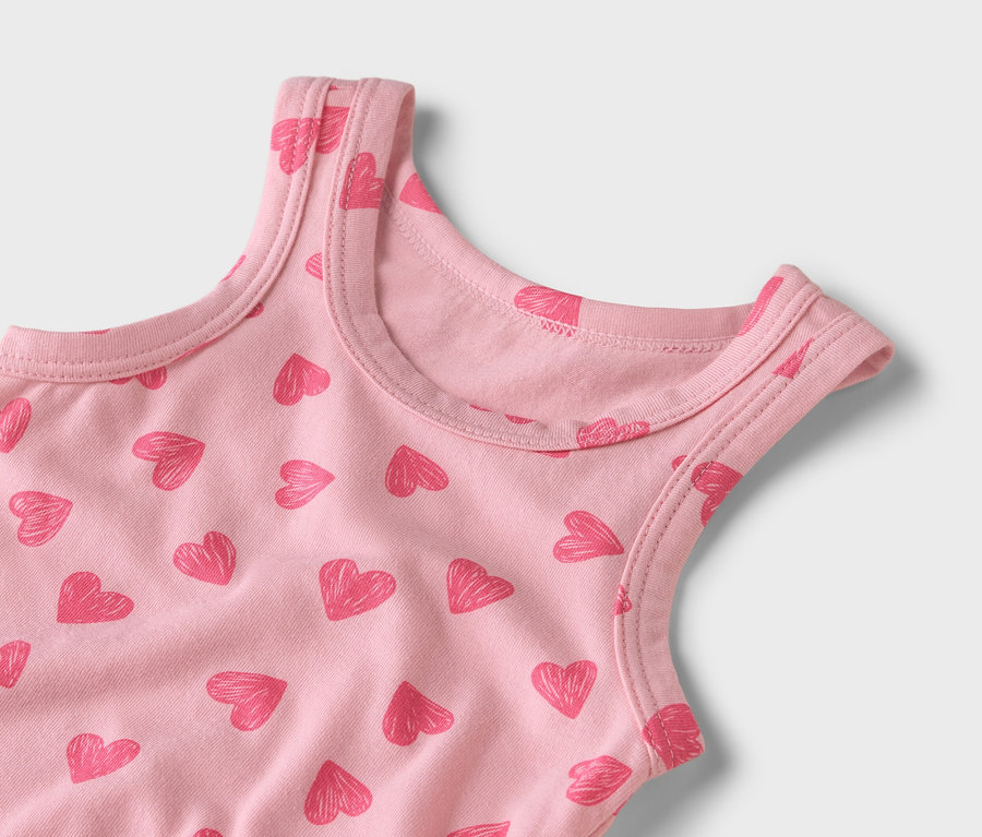 Zbliżenie różowego topu na ramiączkach we wzór czerwonych serduszek.