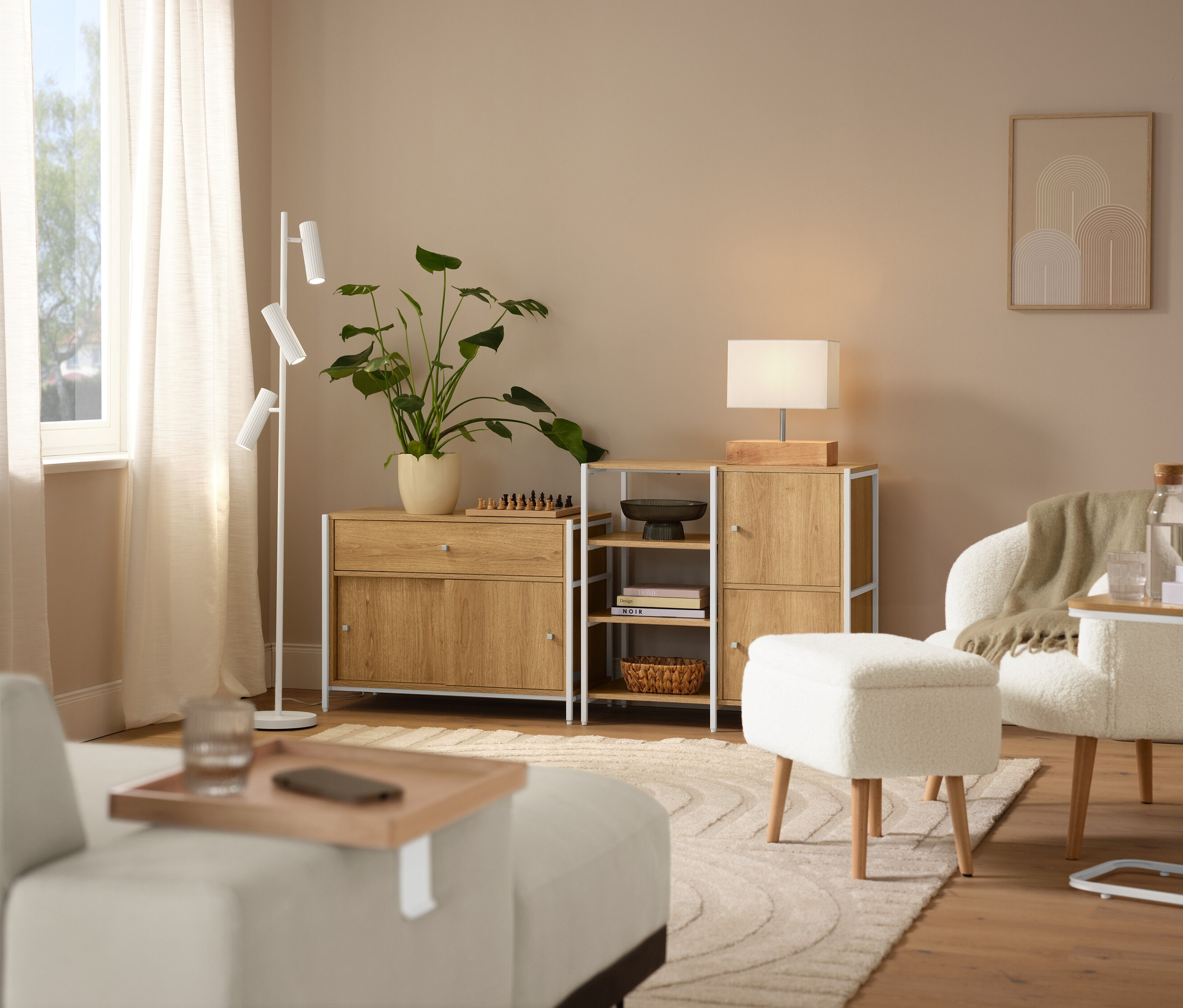 Aranżacja wnętrza z beżowym dywanem »Cosmo«, fotelem z tkaniny bouclé z drewnianymi nogami i lampą stołową z drewnianą podstawą.