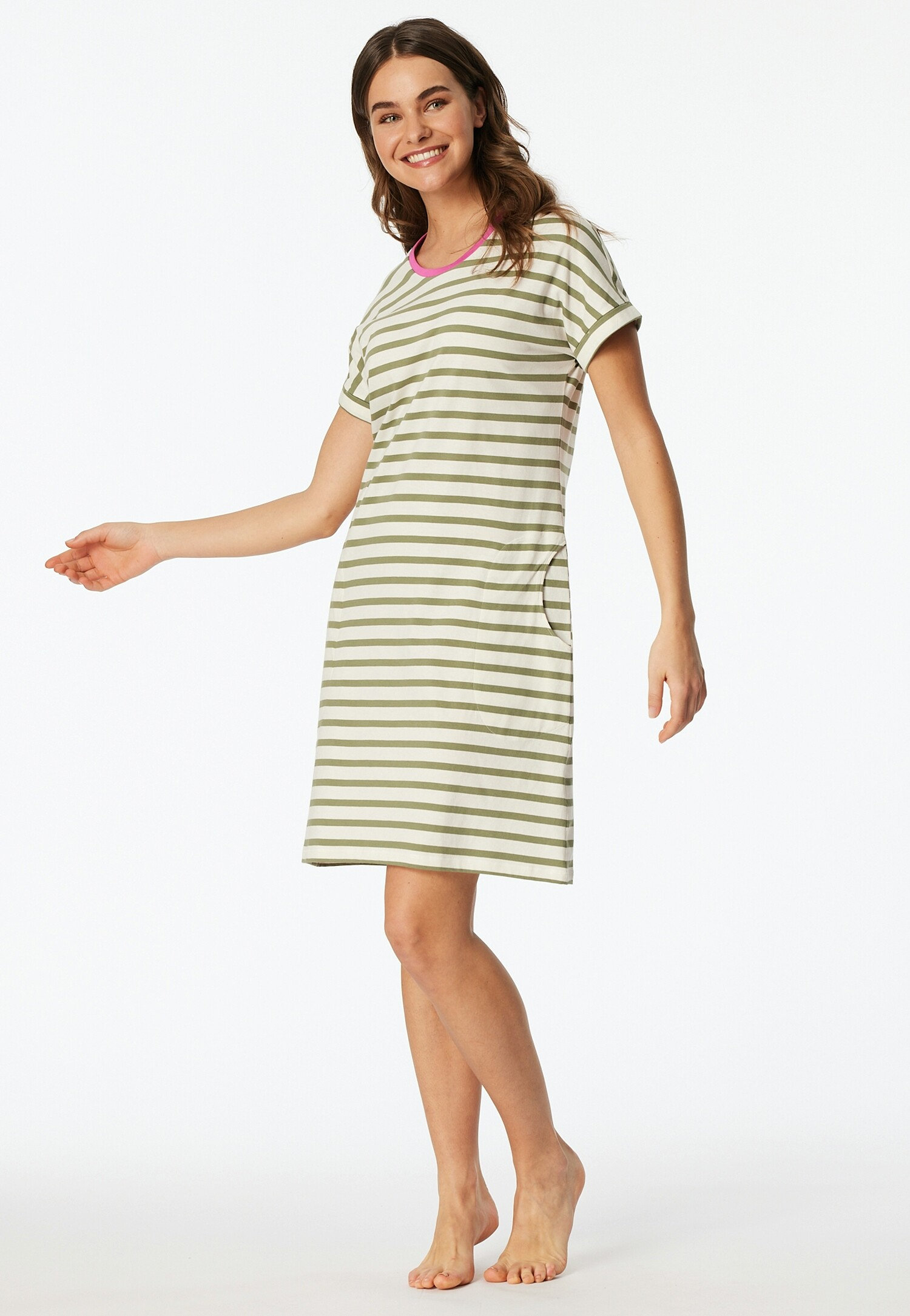 Kobieta ma na sobie sukienkę w paski z różowymi akcentami przy dekolcie.