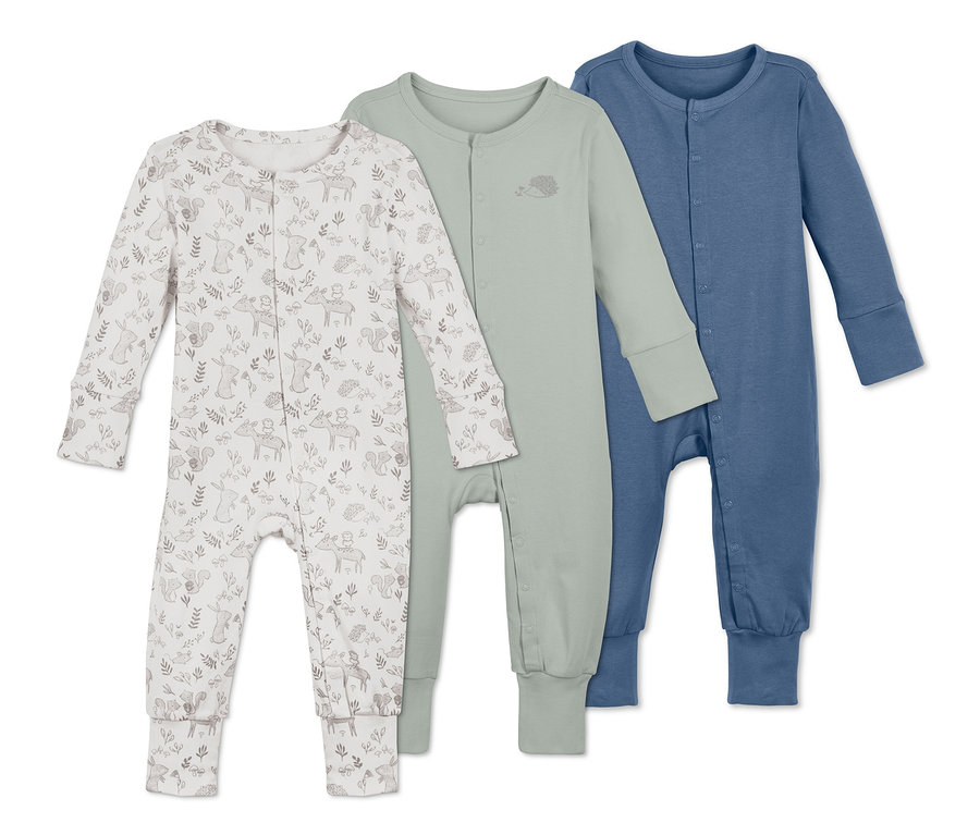 Trzy bawełniane piżamy leżą obok siebie. Jedna piżama jest biała we wzory zwierząt leśnych, jedna jest zielona, a jedna niebieska.