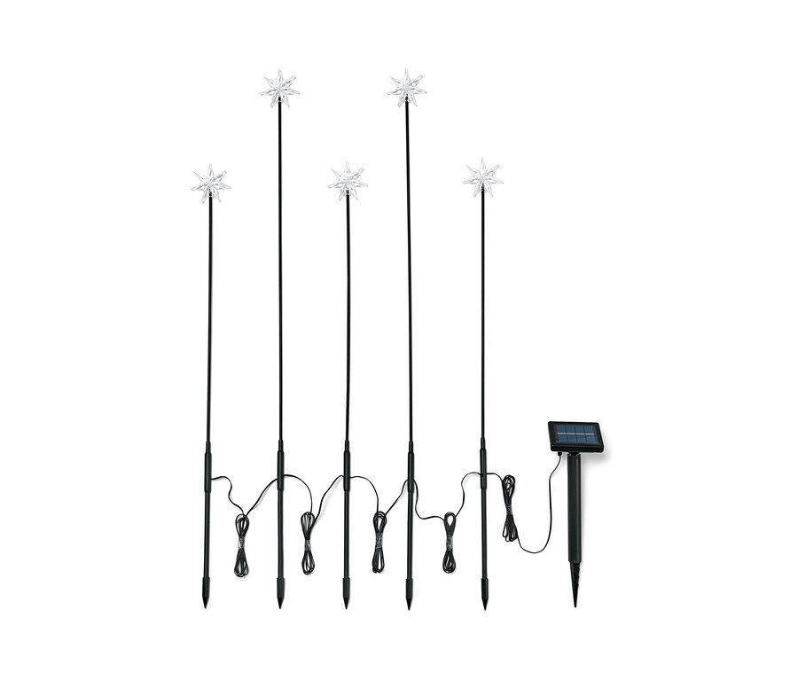 Pięć pałeczek solarnych z gwiazdami na czarnych tyczkach i panel słoneczny.