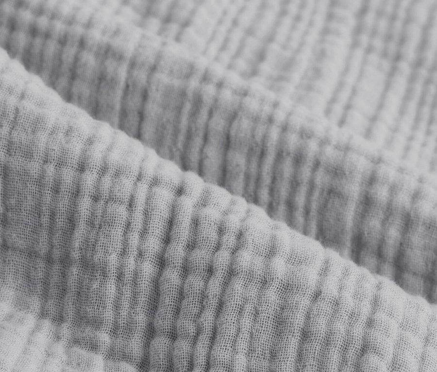 Zbliżenie na szarą pościel muślinową w rozmiarze standardowym i niestandardowym.