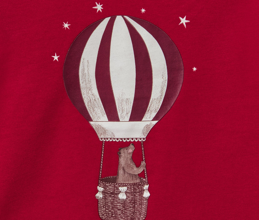 Zdjęcie czerwonej piżamy dziecięcej „Balon”, świecącej w ciemności z misiem w balonie na ogrzane powietrze.