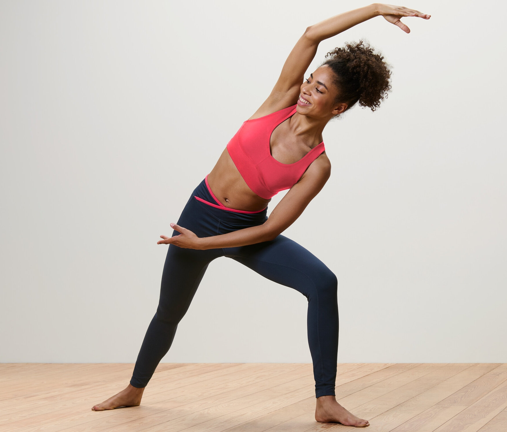 Kobieta rozciąga się w legginsach sportowych.