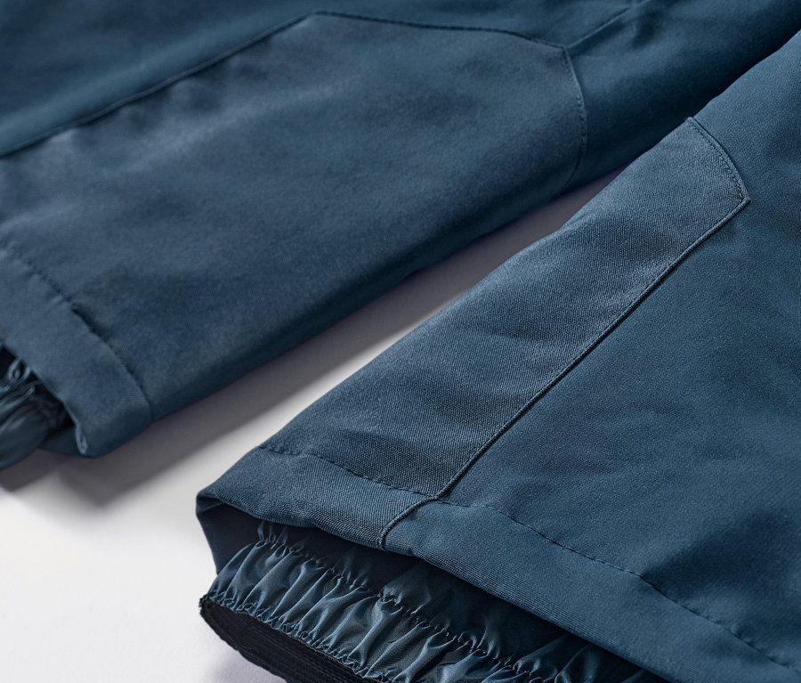 Szczegół granatowych spodni narciarskich i snowboardowych.