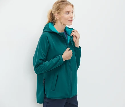 Kobieta zapina kurtkę softshell.