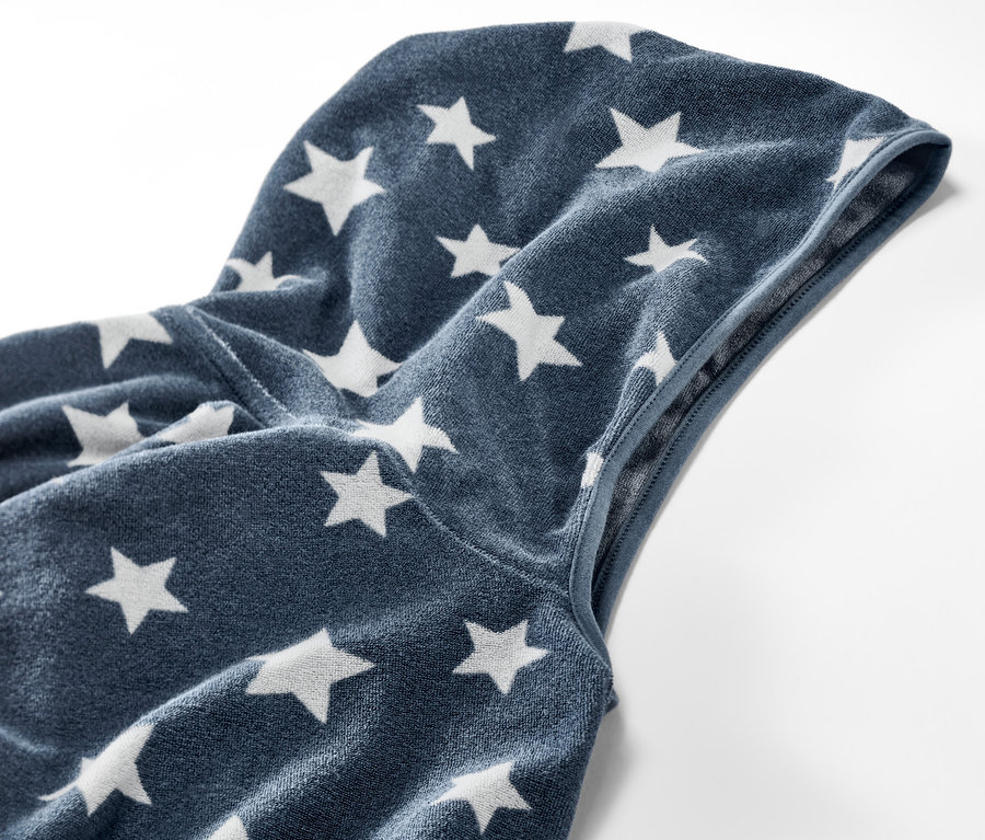 Zbliżenie na dziecięce ponczo z tkaniny frotté z kapturem i wzorem w gwiazdy.