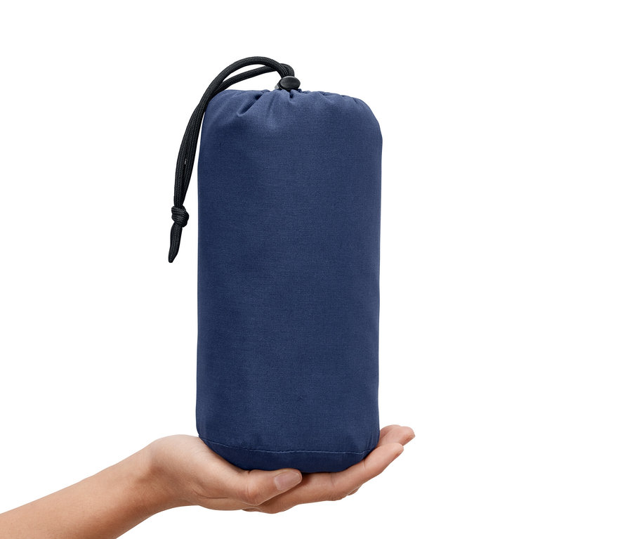 Ręka trzyma niebieski wkład do śpiwora ze sznurkiem.