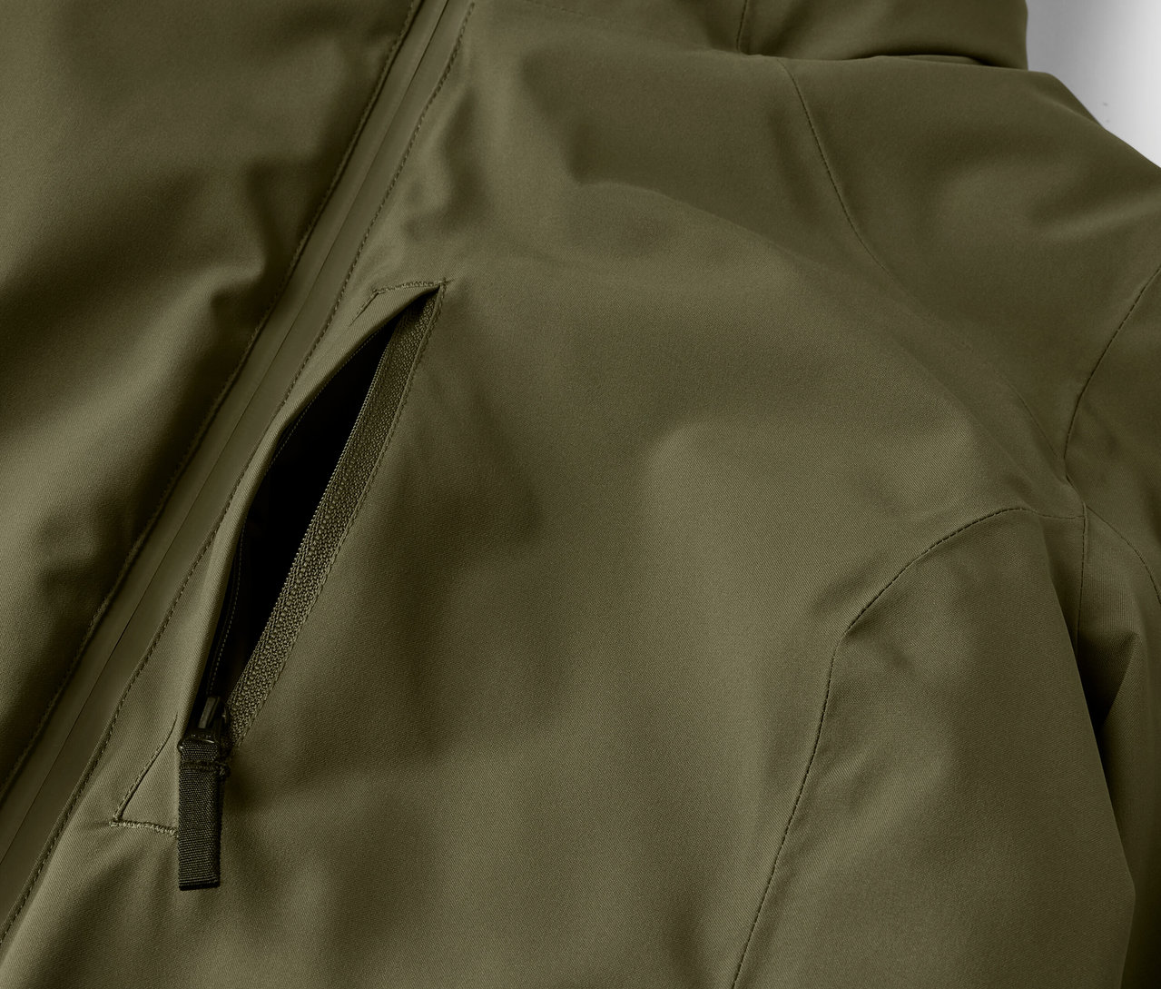 Zbliżenie na oliwkową kurtkę z kieszenią na zamek.