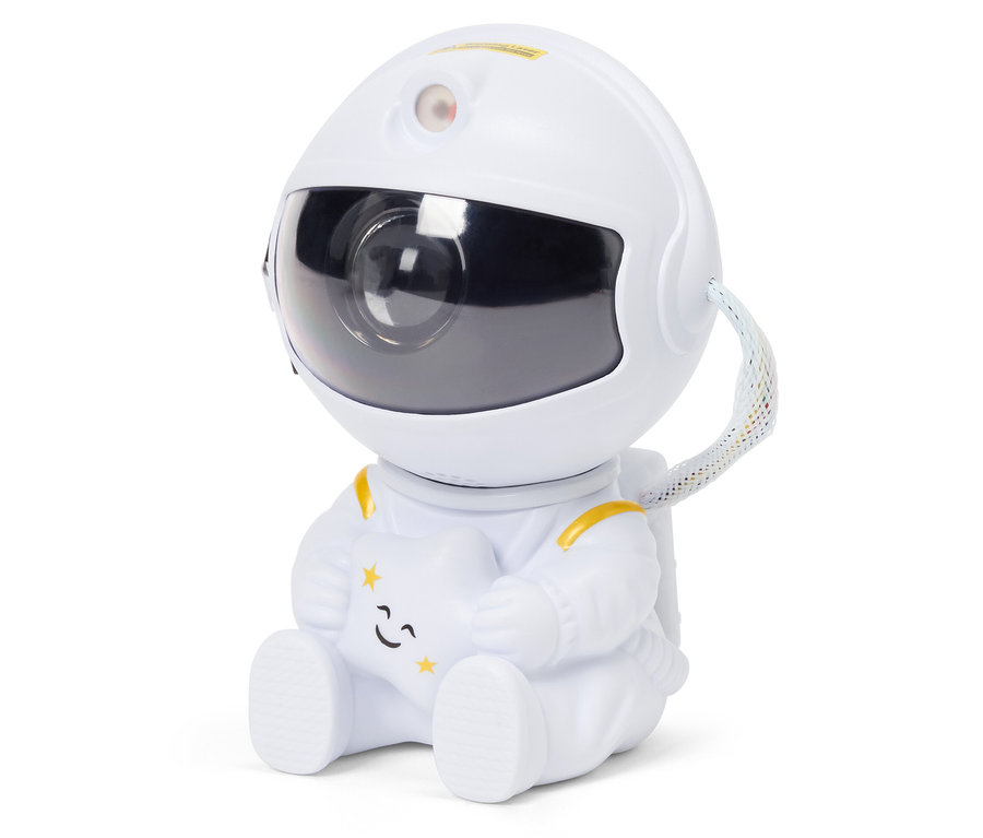 Astronauta w białym kombinezonie siedzi i trzyma gwiazdę.