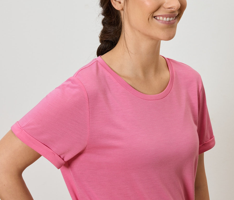 Uśmiechnięta brunetka w różowym T-shircie.
