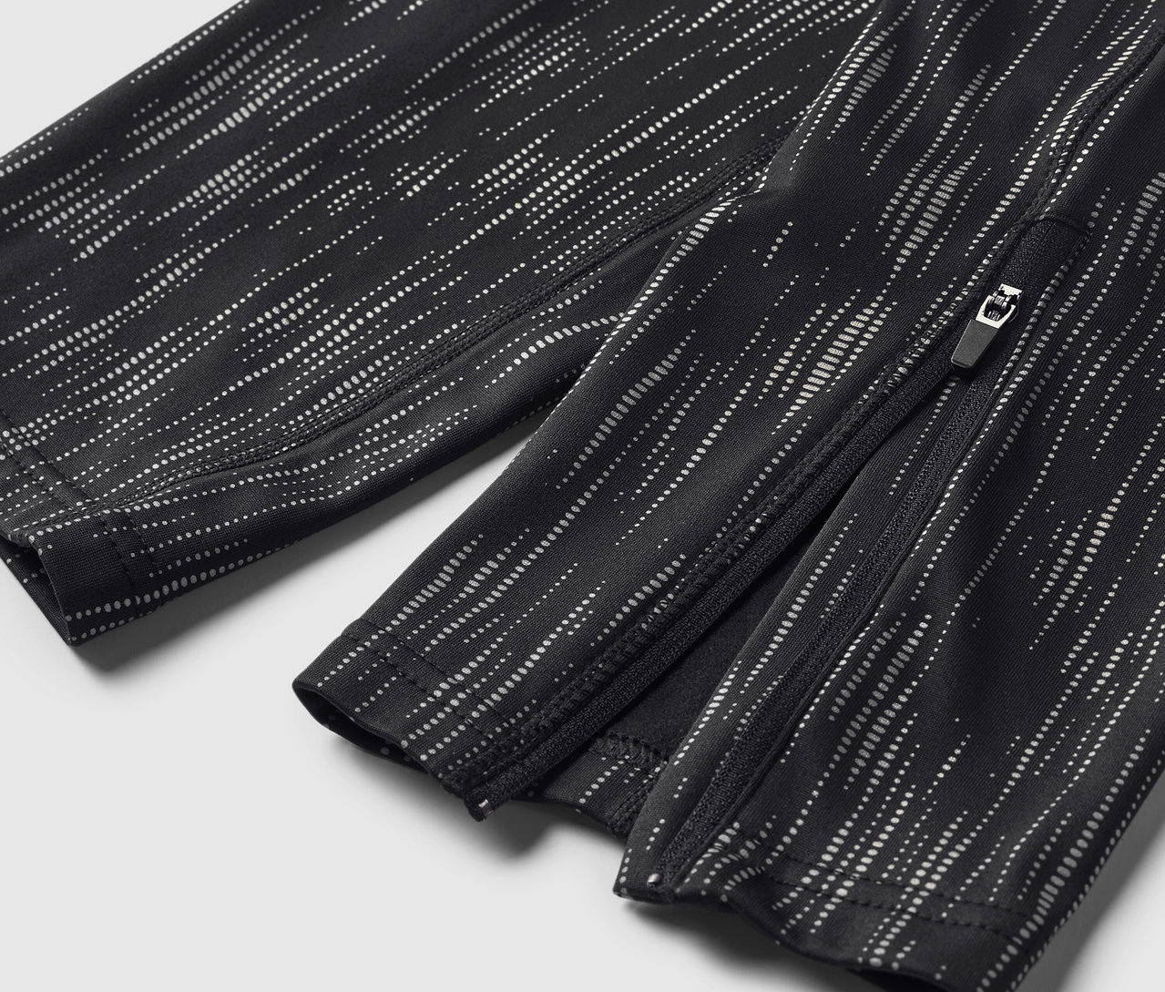 Zbliżenie na czarno-białe spodnie we wzory z zamkiem błyskawicznym przy kostce.