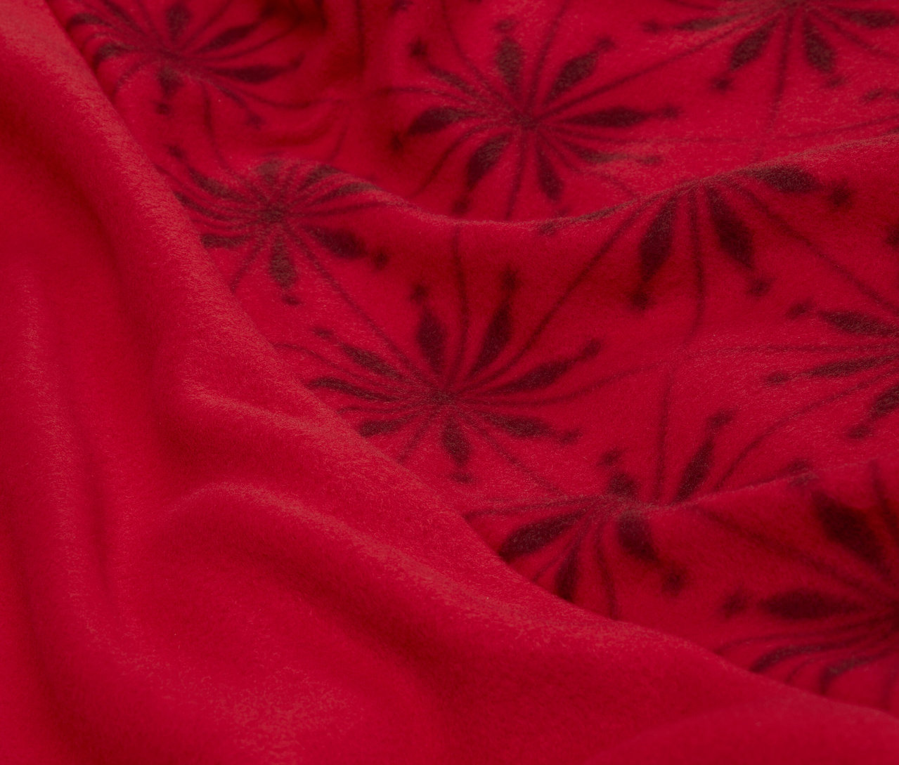 Zbliżenie na czerwoną tkaninę z ciemnym kwiatowym wzorem.